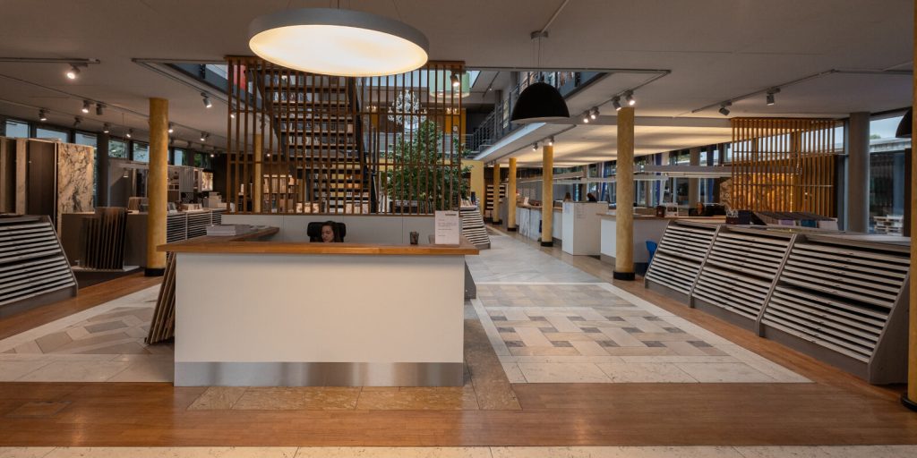 Innenraum einer Ausstellung mit Empfangsbereich und Designpräsentationen