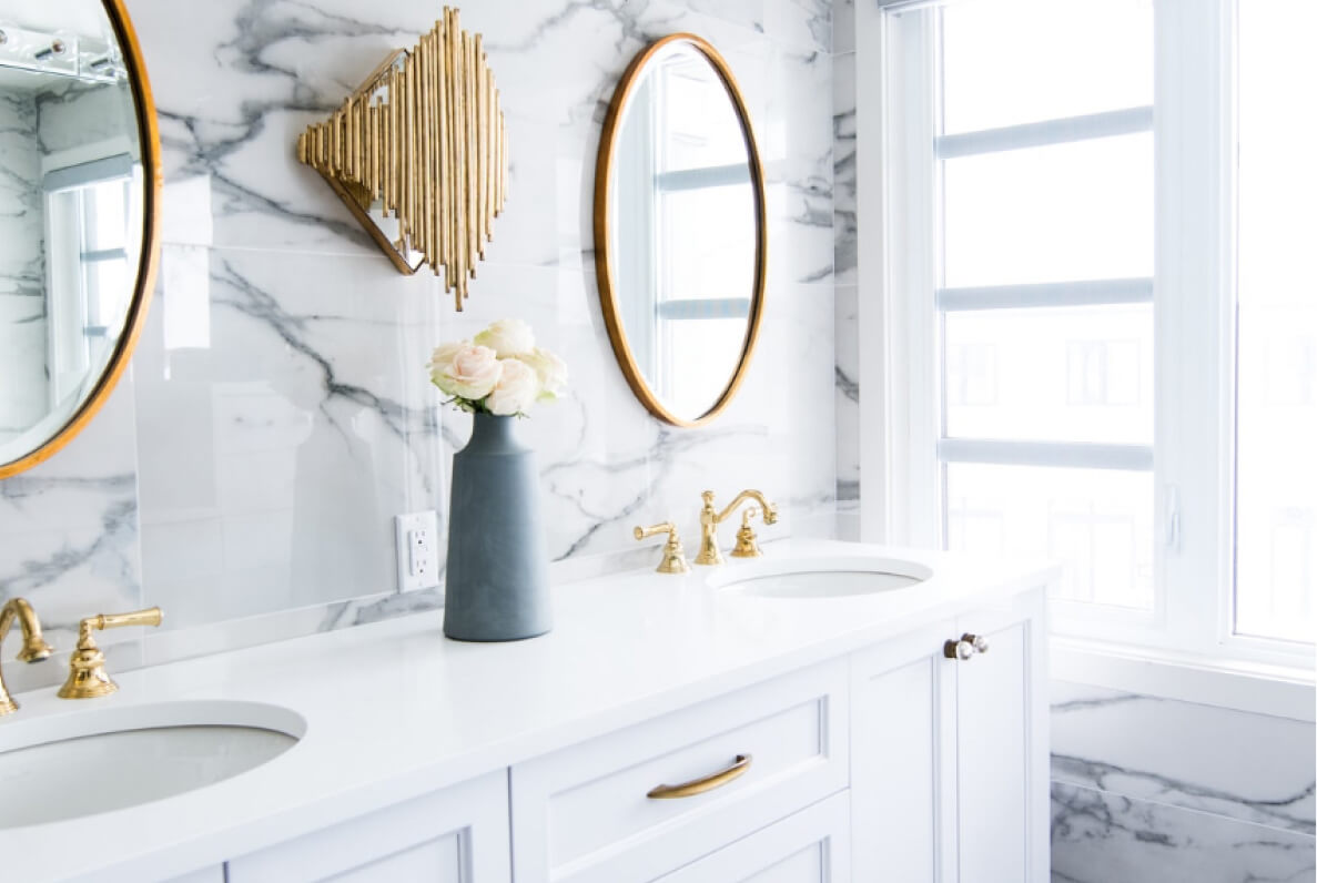 Helles Bad mit Marmorfliesen und goldenen Armaturen