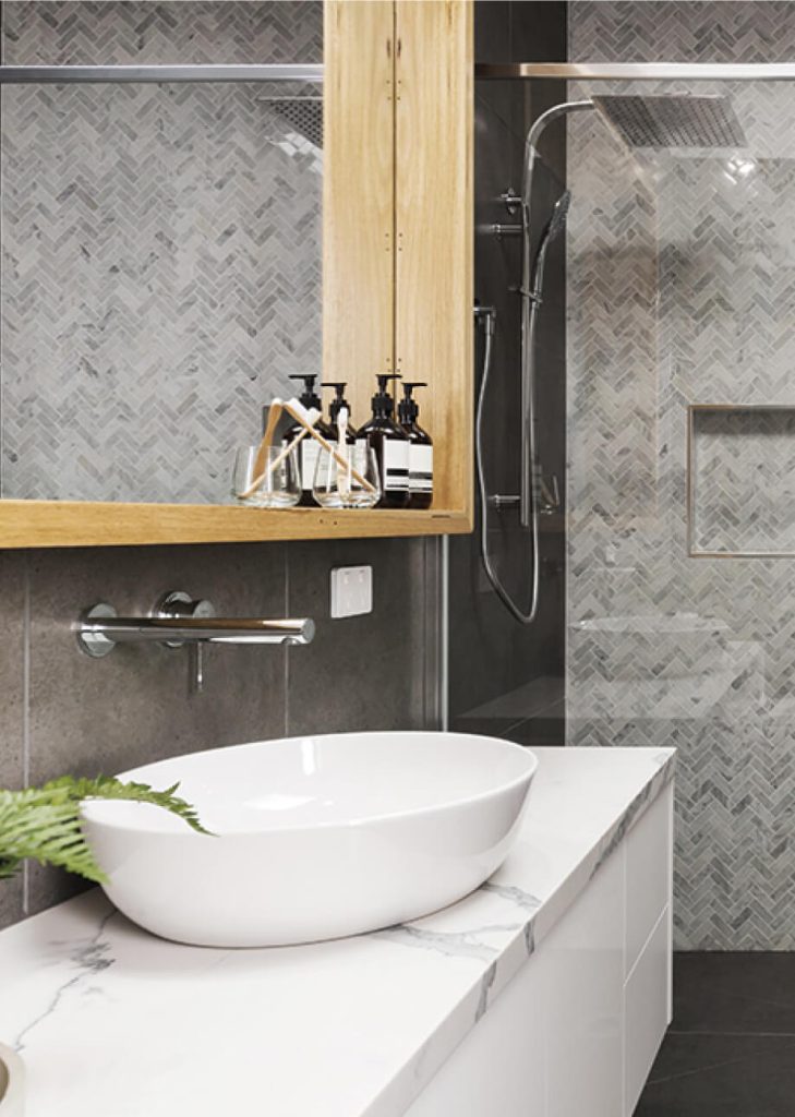 Modernes Badezimmer mit grauen Fliesen und weißem Waschbecken