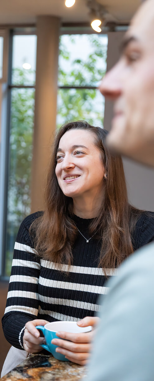 Junge Frau lacht während eines Gesprächs im Büro oder Showroom