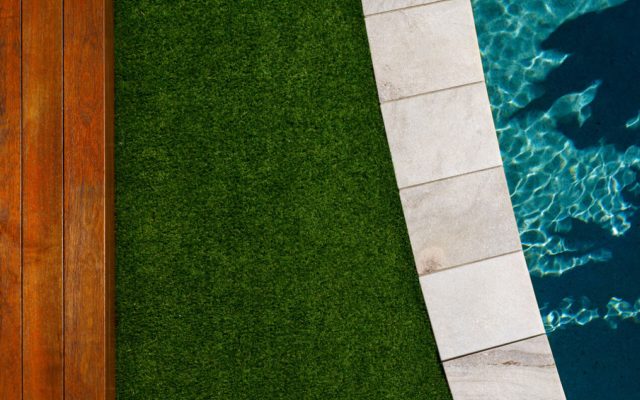 Terrasse mit Rattanmöbeln, großen Pflanzen und Ziegelboden