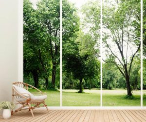 Terrasse mit Holzdielen und Blick auf grünen Garten durch große Glasfront