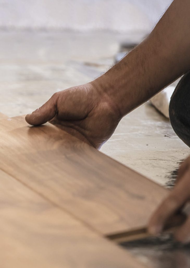 Handwerker verlegt Holzdielen und passt sie an