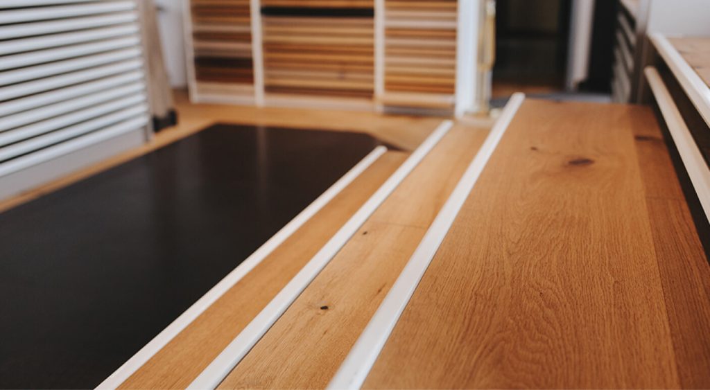 Detailaufnahme von Holzdielen mit Schienensystem für die Montage