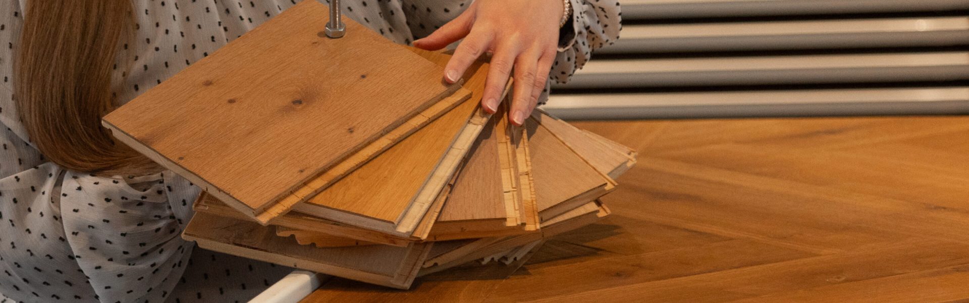 Frau hält mehrere Holzbodenmuster zur Auswahl