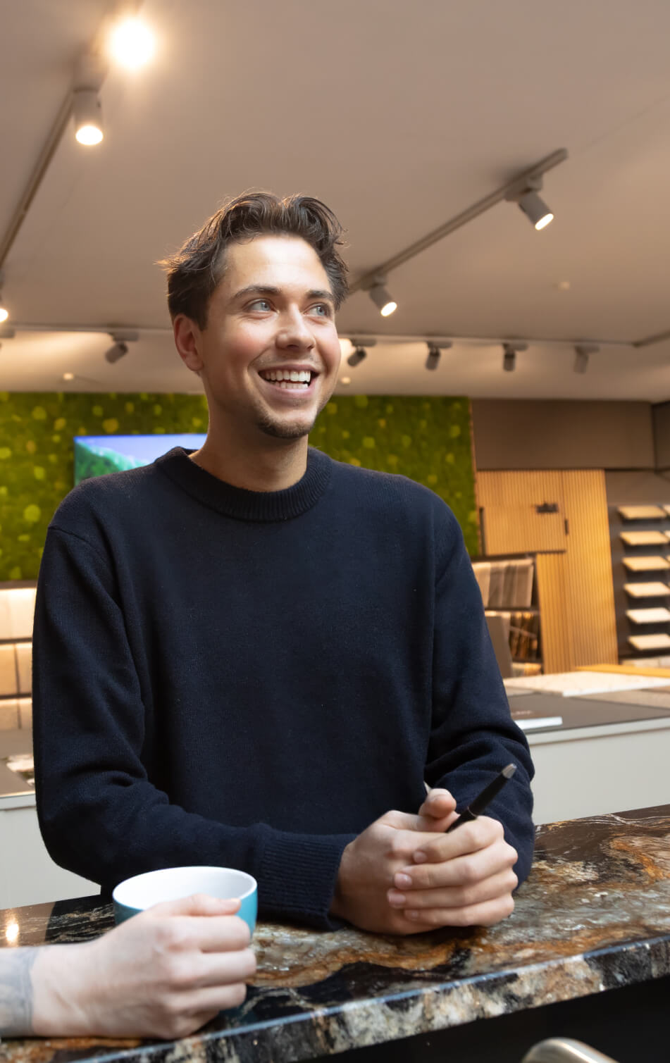 Mitarbeiter in modernem Showroom lächelt in die Kamera