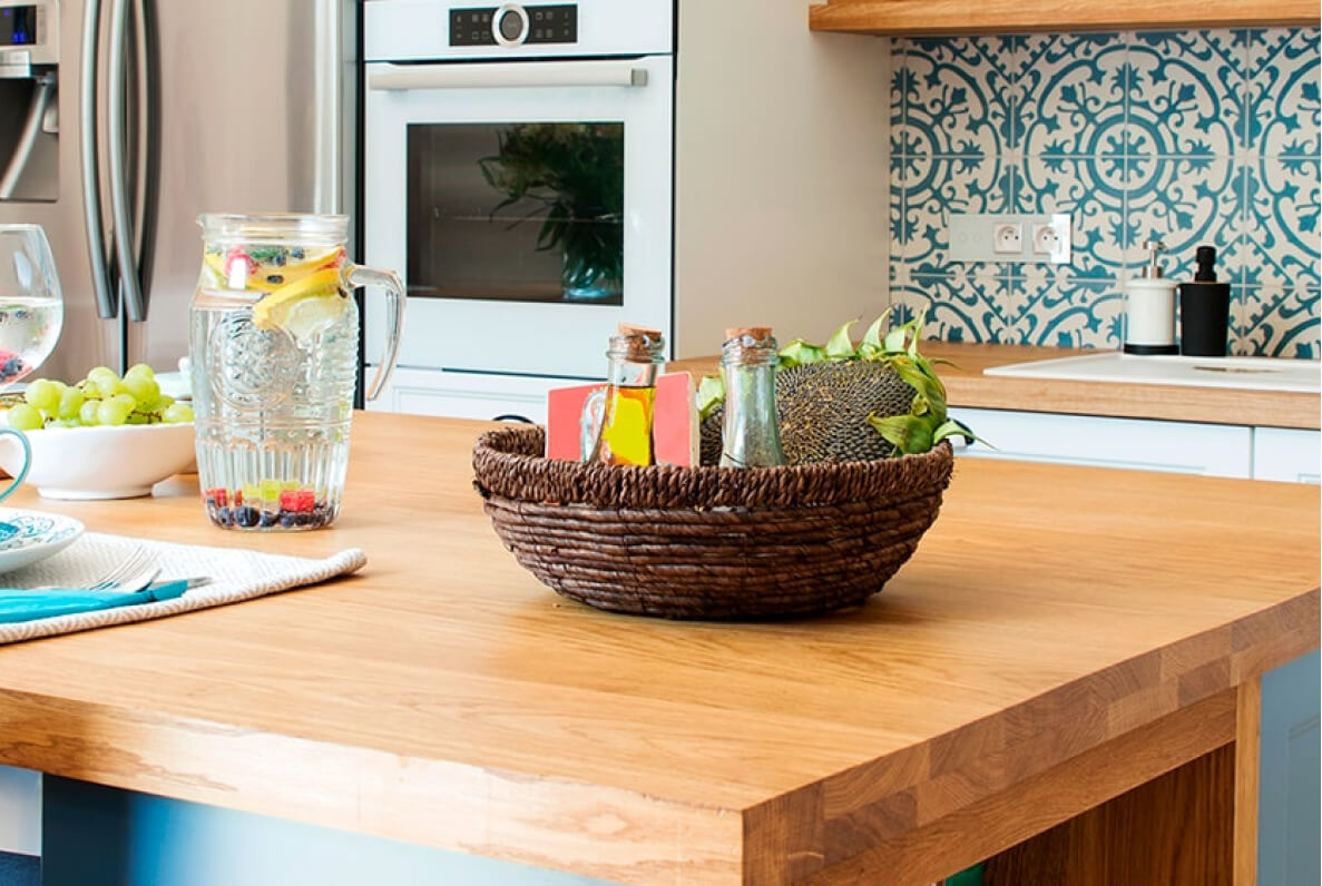 Küche mit Holzarbeitsplatte und geflochtenem Obstkorb