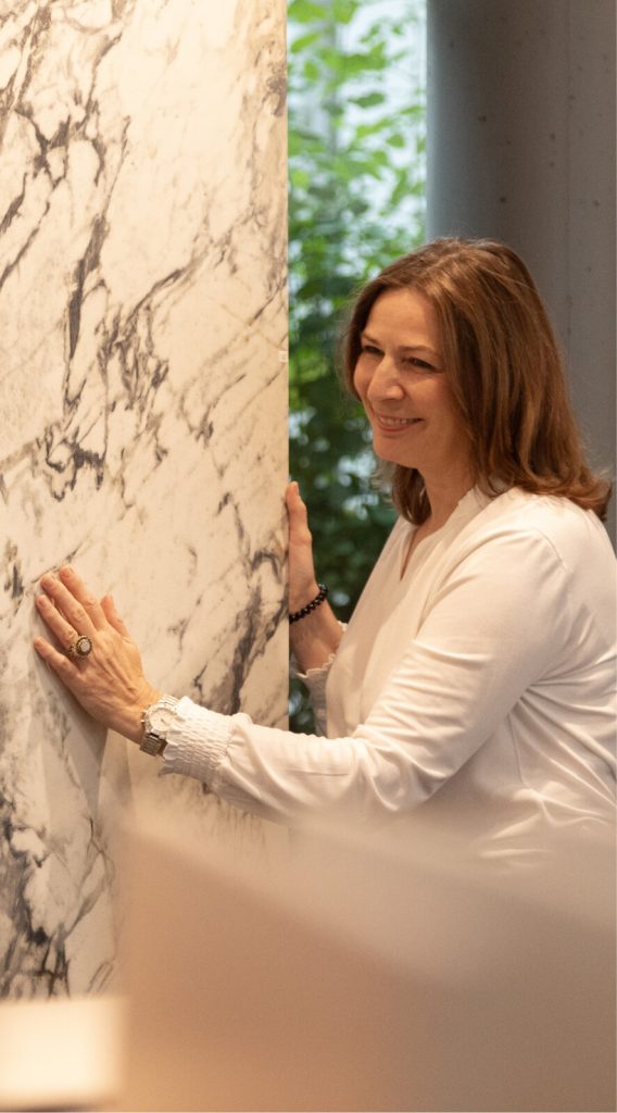 Frau begutachtet eine weiße Marmorplatte