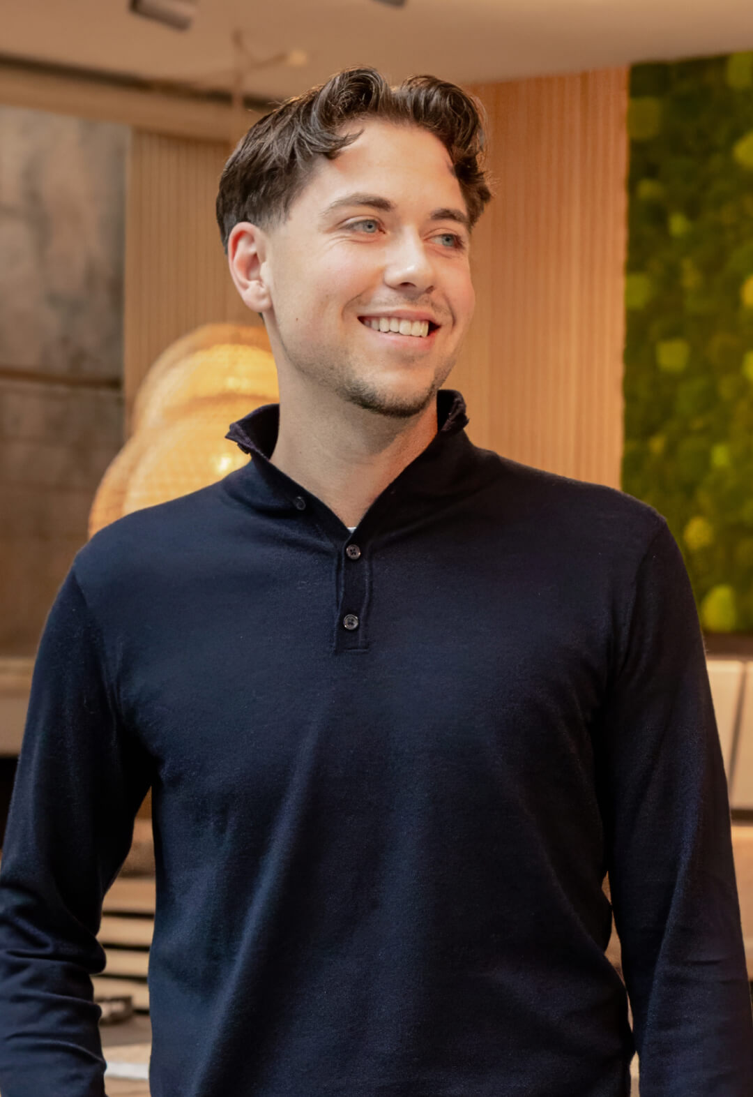 Mann im dunkelblauen Pullover in modernem Ambiente