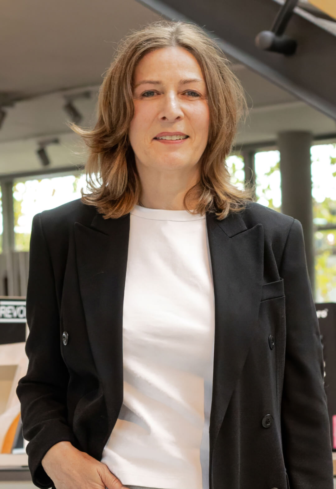 Frau im schwarzen Blazer in modernem Innenraum