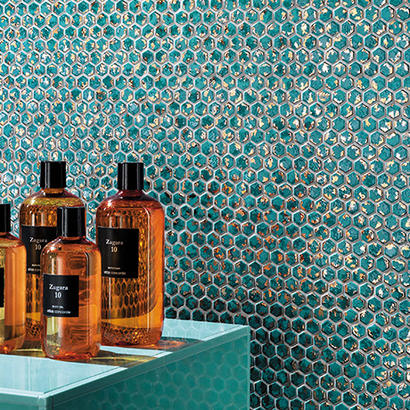 Braune Kosmetikflaschen auf türkisfarbener Mosaikfläche