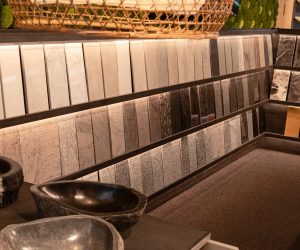 Badezimmerausstellung mit großen Natursteinfliesen und Dekoelementen