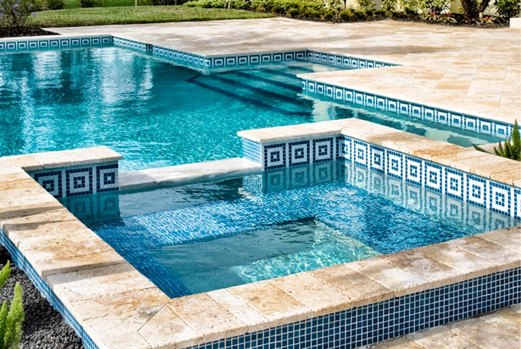 Swimmingpool mit Mosaikmustern und heller Steinumrandung