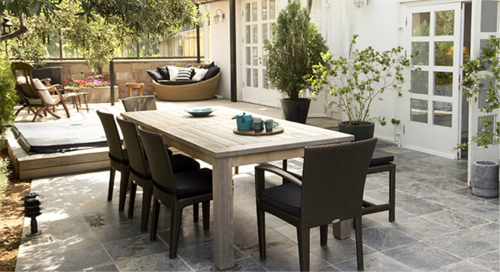 Outdoor-Essbereich mit Steinplatte als Tisch und dunklen Stühlen