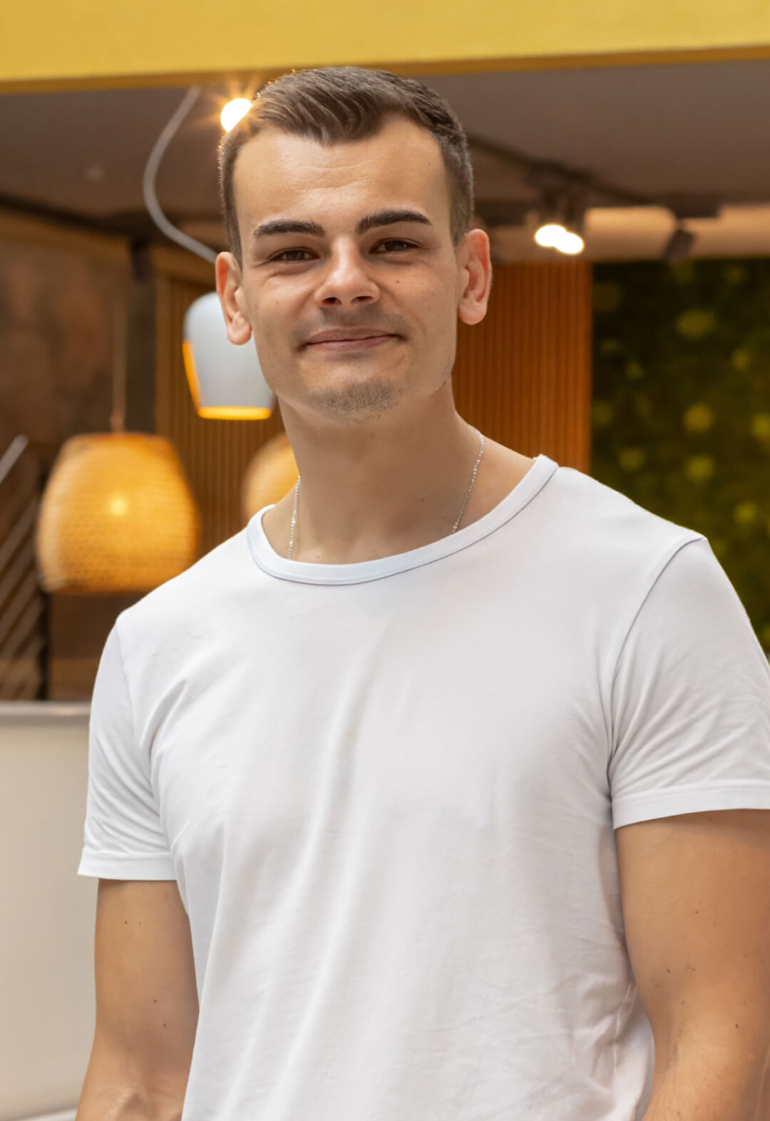 Junger Mann im weißen T-Shirt in einer modern beleuchteten Umgebung