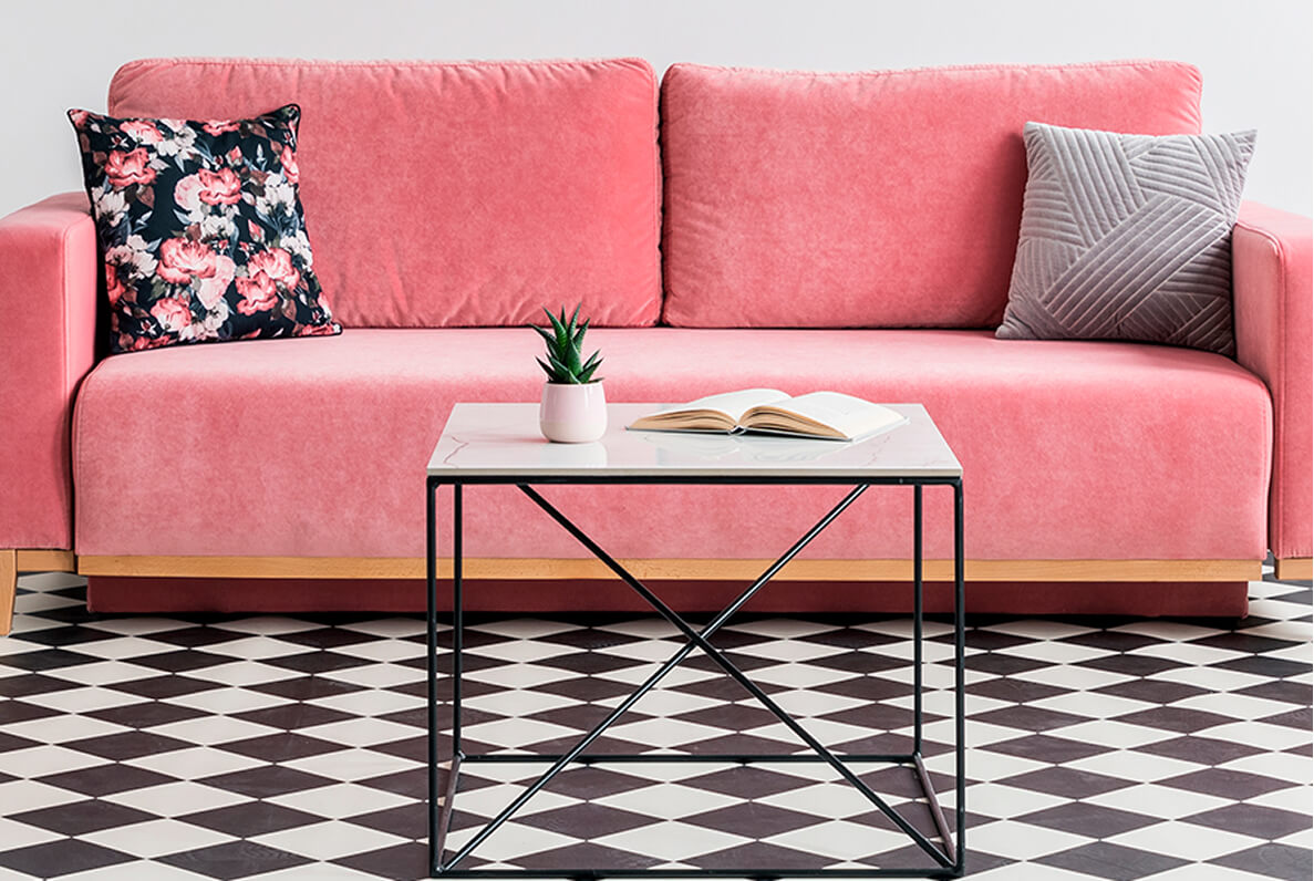 Pinkes Sofa in modernem Wohnzimmer auf schwarz-weiß gemustertem Boden