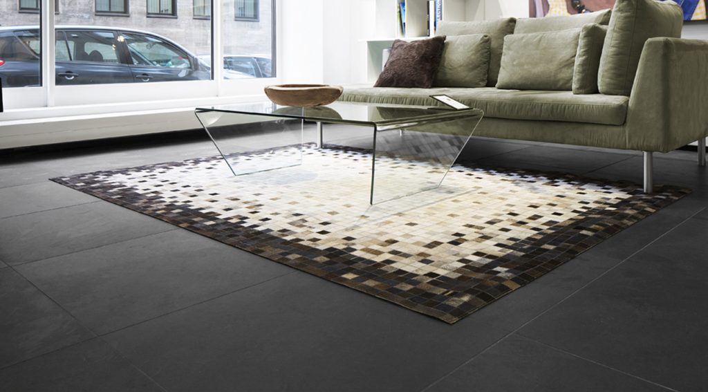 Modernes Wohnzimmer mit grauem Sofa und gemustertem Teppich